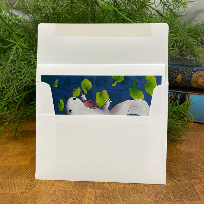 White card in white envelope with a colorful illustration of a white axolotl in a blue pond.