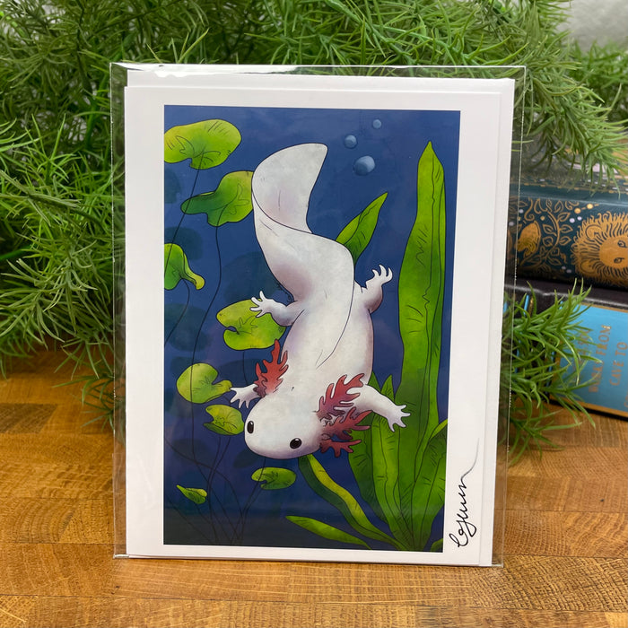 Greeting card with axolotl illustration with white envelope packaged in clear bag.