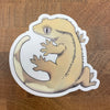 Sticker of a beige crested gecko photographed on a wooden surface